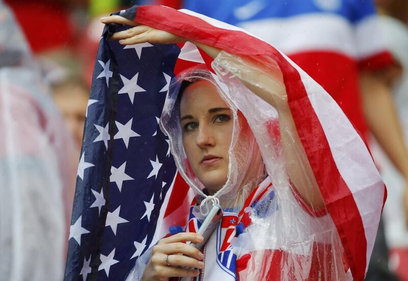 A fan of the United States drapes the national flag over herself as it rains before their 2014 World Cup Group G match against Germany on Thursday in Recife, Brazil. Laszlo Balogh / Reuters