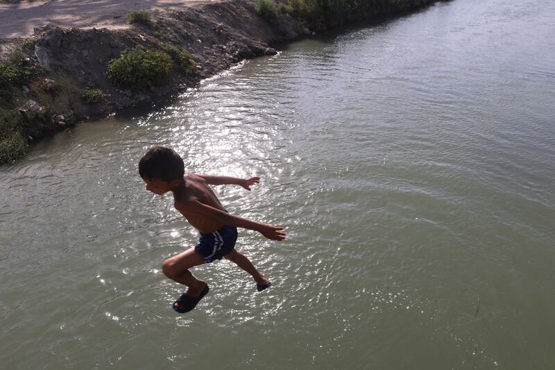 A boy dives into a river in the village of Albu Mustafa, near Hilla in central Iraq. AFP