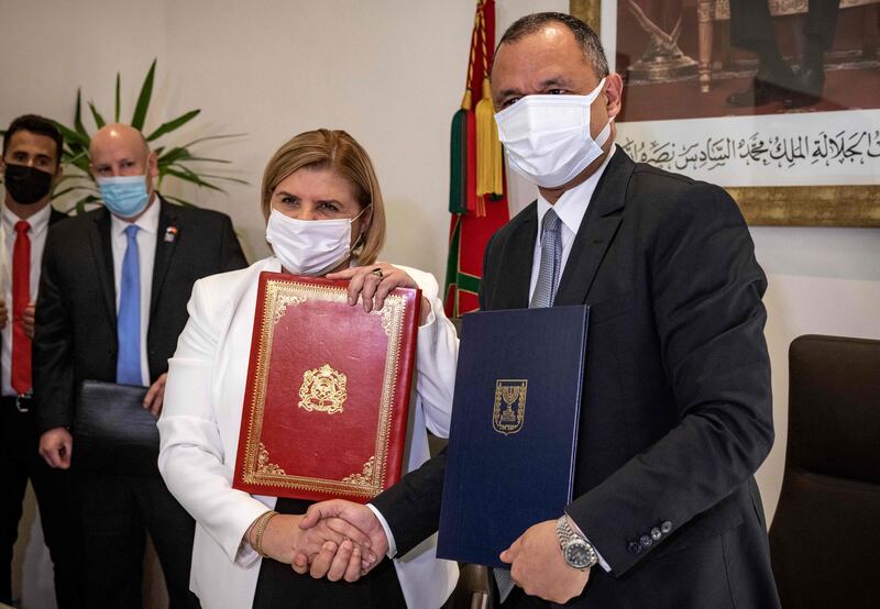 Ryad Mezzour, Morocco's Industry and Trade Minister, shakes hands with Orna Barbivai,  Israel's Economy Minister after signing a trade agreement between the two countries in Rabat. AFP