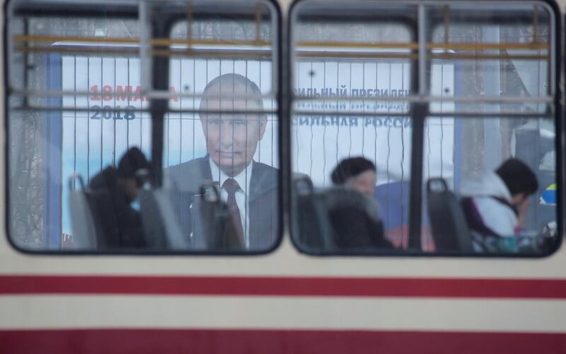 People ride a tram past a board in St Petersburg advertising Russian President Vladimir Putin's  presidential election campaign. Anton Vaganov / Reuters