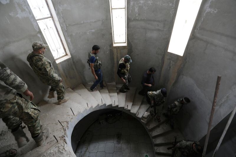 Turkey-backed Syrian rebel fighters walk inside a building they use to shelter near the border town of Tal Abyad. Reuters