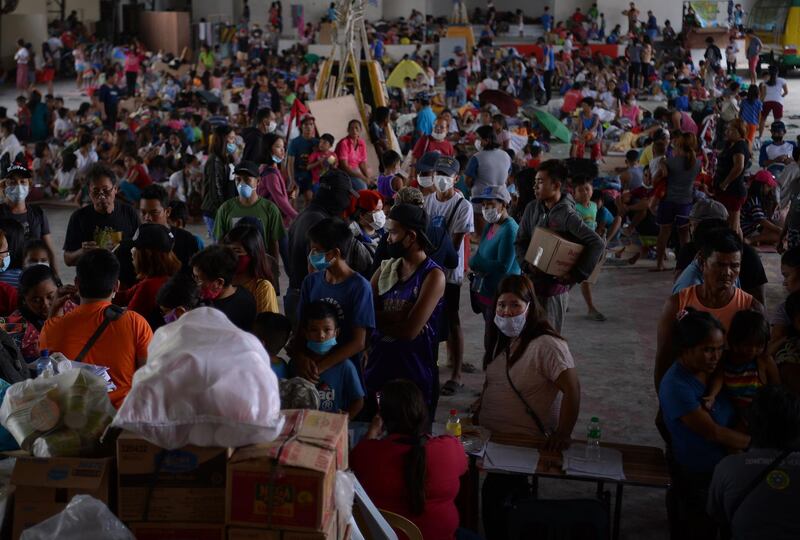 Evacuees from towns affected by the eruption of Taal volcano queue up at an evacuation center in Tanauan town, Batangas province south of Manila.  AFP