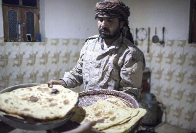 Mohamed Abu Rayouf , a members of Yemeni resistance forces of Abu Jabr brigade takes bread baked by his wife for the fighters at his house located near a front line position in Zi Naem town of Al-Bayda governorate,  May 9, 2018.  Photo/ Asmaa Waguih 