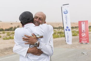 Max Calderan receives a hug of congratulations from a member of his support team after finishing his 340km trek. Courtesy Mauro Grigollo