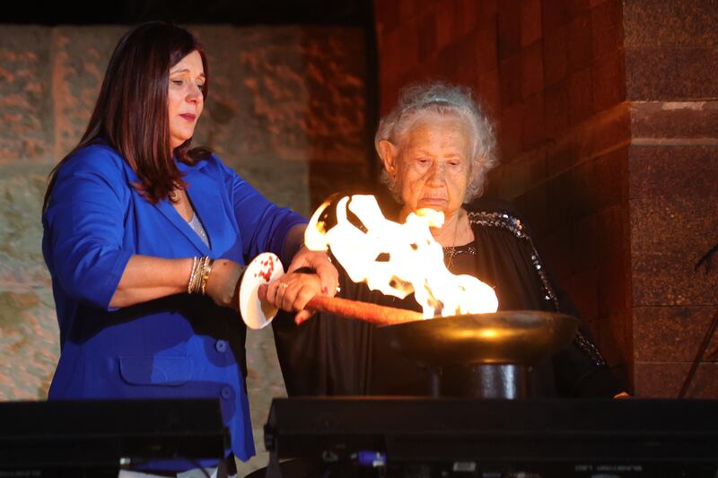 Holocaust survivor Tova Gutstein, right, lights a torch with her daughter at the memorial museum in Jerusalem. EPA