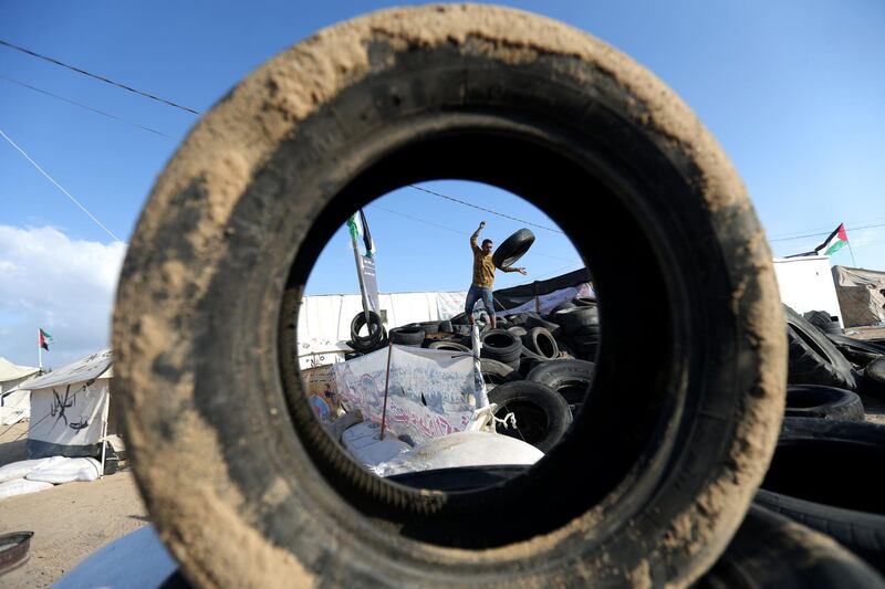 A man carries tyres to be burnt as Palestinians prepare to demonstrate along the border with the Gaza strip, east of Jabalia. Mohammed Abed / AFP