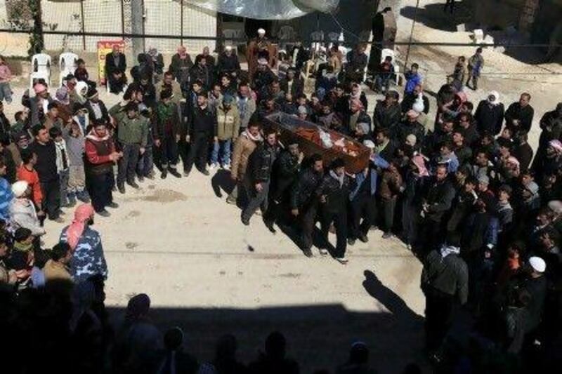 Men carry the coffin of a member of the Free Syrian Army, who was killed by armed civilians loyal to Syria's President Bashar Al Assadin the northern city of Idlib.