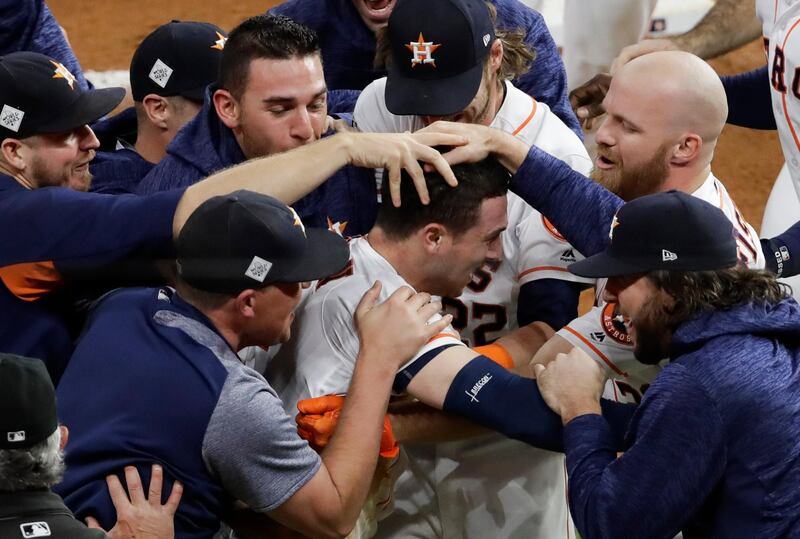 Houston Astros' Alex Bregman is mobbed by teammates after hitting in the game-winning run during the 10th inning of Game 5 of baseball's World Series against the Los Angeles Dodgers Monday, Oct. 30, 2017, in Houston. The Astros won 13-12 to take a 3-2 lead in the series. (AP Photo/Eric Gay)