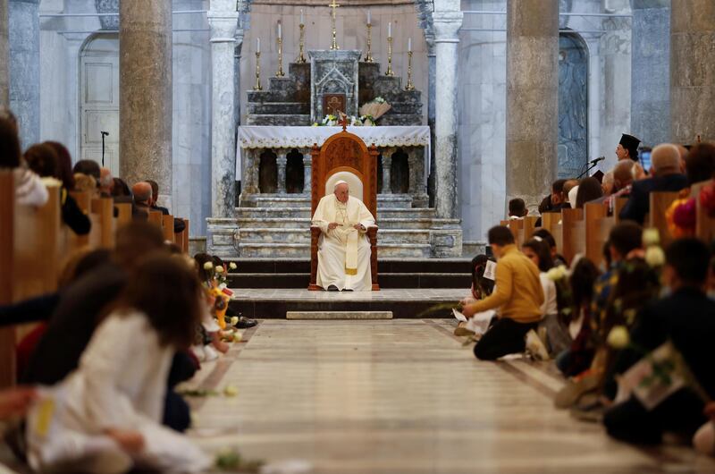 Pope Francis sits down before holding a prayer at the Grand Immaculate Church in the town of Qaraqosh. Reuters