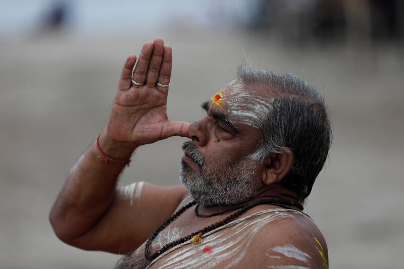 A Hindu holy man performs yoga at Sangam, the confluence of rivers the Ganges and the Yamuna in Prayagraj, India. AP Photo