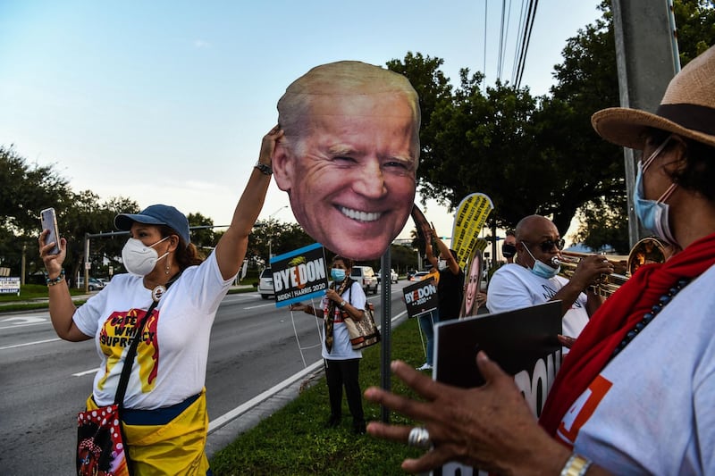 Supporters of the Democratic party hold signs outside the Miami-Dade County Election Department in Miami, Florida.  AFP