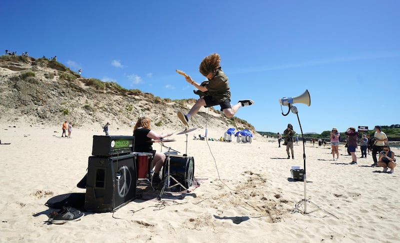 A musician plays on the beach during a gathering of demonstrators outside of a meeting of G7 leaders. AP