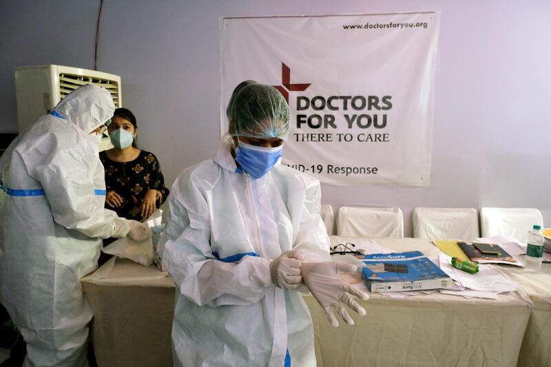 Health workers put on personal protective equipment prior to caring for patients at a makeshift Covid-19 quarantine facility set up in a banquet hall in New Delhi, India. Bloomberg
