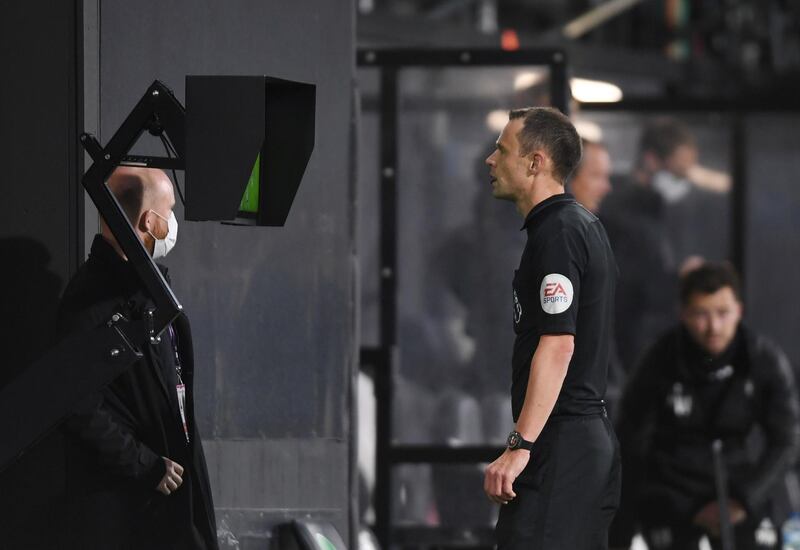 Referee Stuart Attwell refers to VAR after Fulham's goal. The decision was overturned for a foul. Reuters