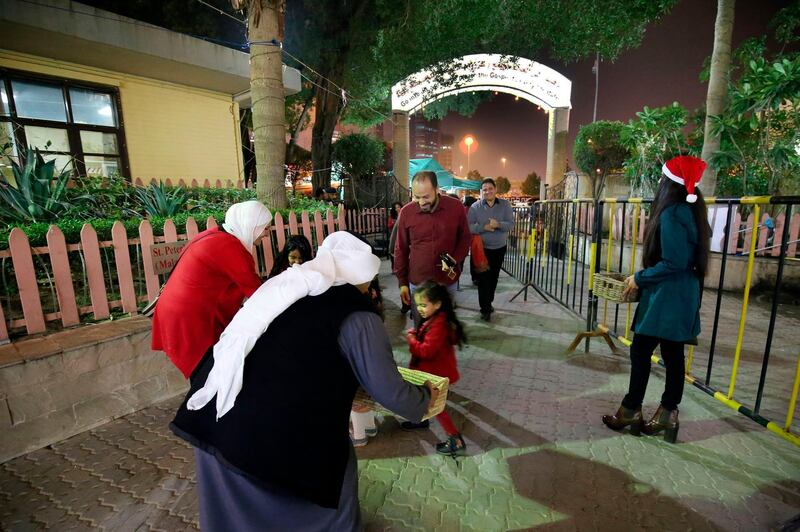 Kuwaiti Muslims distribute sweets during Christmas mass at the National Evangelical Church in Kuwait City. AFP