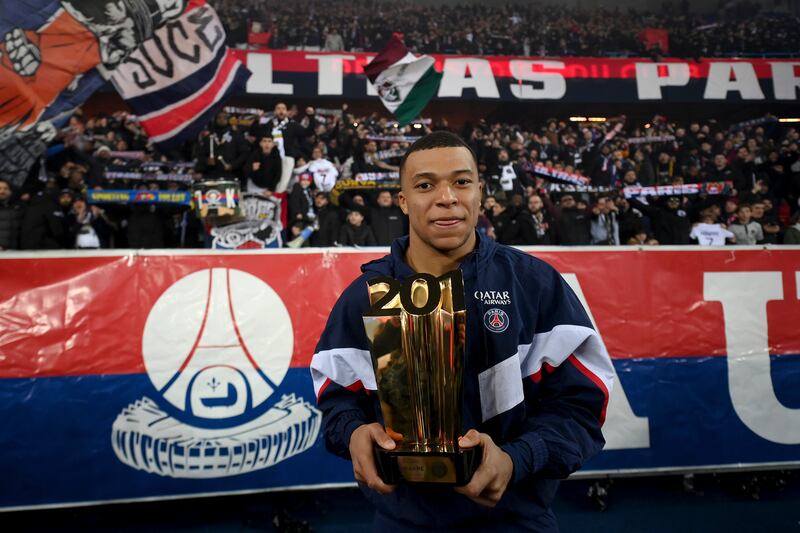 Kylian Mbappe poses with a trophy in front of supporters after he became Paris Saint-Germain's all-time top scorer. AP