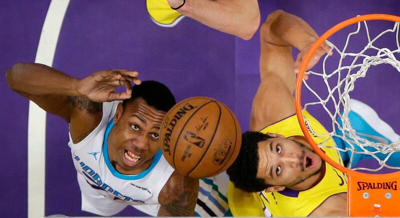 Charlotte Hornets guard Treveon Graham, left, and Los Angeles Lakers guard Josh Hart reach for a rebound during the first half of an NBA basketball game in Los Angeles. Mark Terrill / AP Photo
