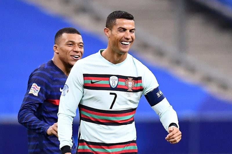 Portugal forward Cristiano Ronaldo, right, jokes with France forward Kylian Mbappe. AFP