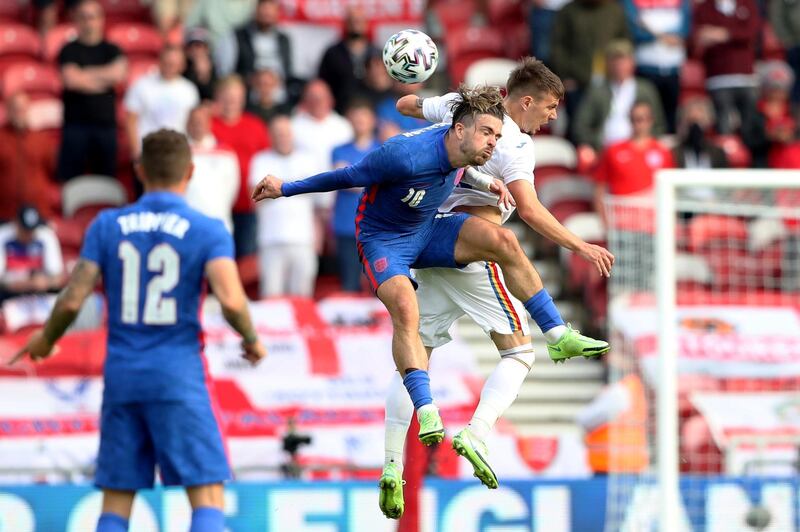 England's Jack Grealish, left, jumps for a header with Romania's Tiberiu Capusa. AP