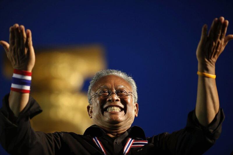 Suthep Thaugsuban, former deputy Prime Minister and protest leader, acknowledges the crowd at the Democracy monument in central Bangkok, where tens of thousands gathered in a protest against a government-backed amnesty bill. Damir Sagolj / Reuters