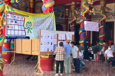 Voters study candidates' details prior to casting their ballots at a polling station in in Bangkok on May 14. AP 