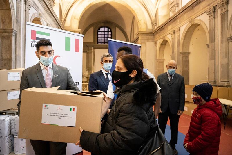 A woman collects a free parcel of winter clothing and essentials donated by Emirates Red Crescent and the Catholic charity Sant'Egidio in Rome. Red Crescent will help disadvantaged people in 25 countries this winter. Wam