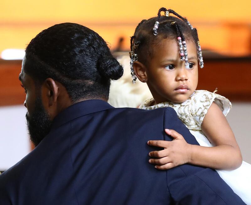 Memory, the 2-year-old daughter of Tomika Miller and Rayshard Brooks, is carried by a funeral home worker.  EPA