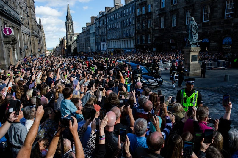 Crowds gather outside St. Giles' Cathedral on the Royal Mile as the queen's coffin passes in Edinburgh. Bloomberg