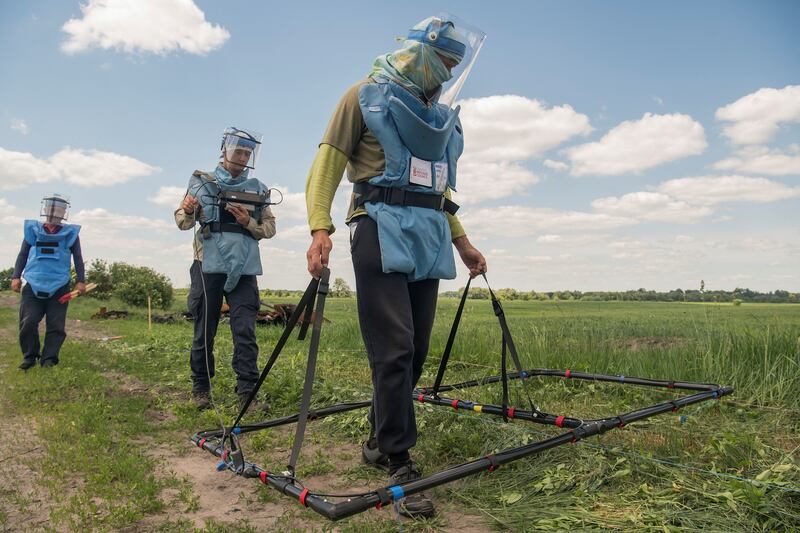 Volunteers from a Danish NGO demonstrate how to search for explosive devices with help of a loop metal detector, outside the town of Ichnia in Ukraine. Reuters