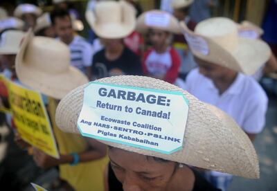 This file photo taken on September 9, 2015, shows environmental activists rallying outside the Philippine Senate in Manila to demand that scores of containers filled with household rubbish be shipped back to Canada.  The Philippines recalled its ambassador to Canada after Ottawa missed Manila's deadline for it to take back tonnes of trash illegally shipped to the nation, its foreign minister said on May 16, 2019. - 
 / AFP / JAY DIRECTO
