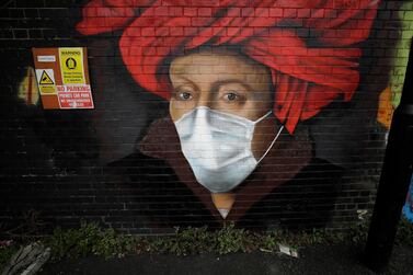 A mural by street artist Lionel Stanhope with a face mask reference to coronavirus painted on a bridge wall in Ladywell, south east London, Thursday, April 2, 2020. The new coronavirus causes mild or moderate symptoms for most people, but for some, especially older adults and people with existing health problems, it can cause more severe illness or death. (AP Photo/Matt Dunham)