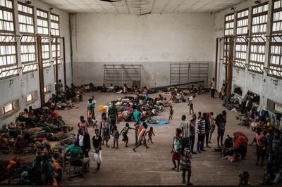 TOPSHOT - People from the isolated district of Buzi take shelter in the Samora M. Machel secondary school used as an evacuation center in Beira, Mozambique, on March 21, 2019, following the devastation caused by Cyclone Idai. Aid workers raced against time to help survivors and meet spiralling humanitarian needs in three southern African countries battered by the region's worst storm in years. Six days after tropical cyclone Idai cut a swathe through Mozambique, Zimbabwe and Malawi, the confirmed death toll stood at more than 300 and hundreds of thousands of lives were at risk, officials said. / AFP / Yasuyoshi CHIBA
