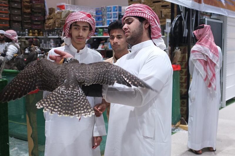 A group of young Emirati falcon fans hold a falcon at the show at ADNEC. Delores Johnson / The National