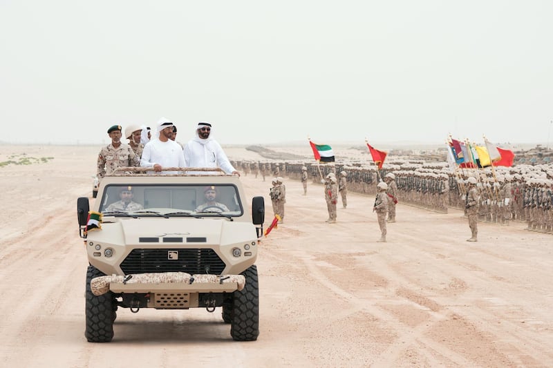 AL DHAFRA REGION, ABU DHABI, UNITED ARAB EMIRATES - April 08, 2018: HH Sheikh Mohamed bin Zayed Al Nahyan Crown Prince of Abu Dhabi Deputy Supreme Commander of the UAE Armed Forces (in vehicle - 2nd L) inspects members of the UAE Armed Forces, during a military exercise titled ‘Homat Al Watan 2 (Protectors of the Nation)’, at Al Hamra Camp. Seen with HE Lt General Hamad Thani Al Romaithi, Chief of Staff UAE Armed Forces (in vehicle - L).

( Rashed Al Mansoori / Crown Prince Court - Abu Dhabi )
---