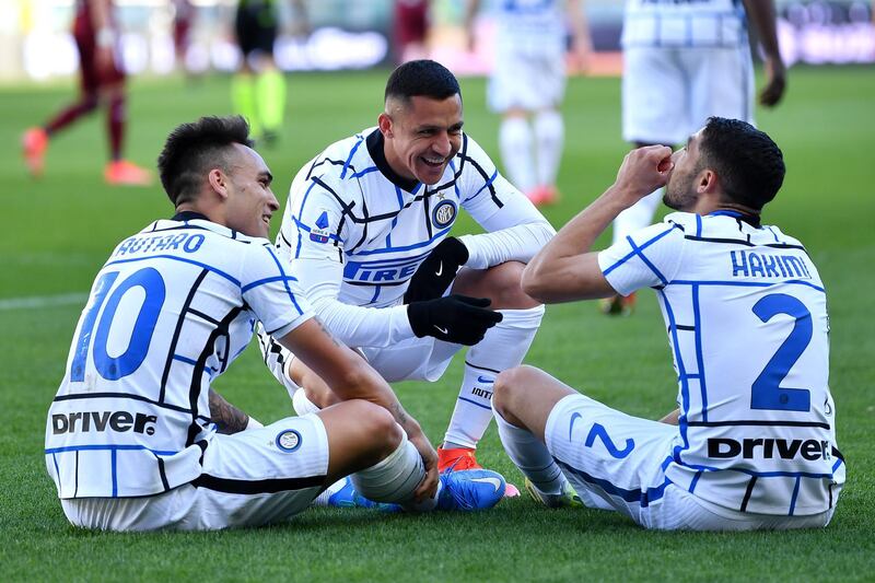 Inter Milan's Argentine forward Lautaro Martinez celebrates with Alexis Sanchez, left, and Achraf Hakimi after scoring. AFP