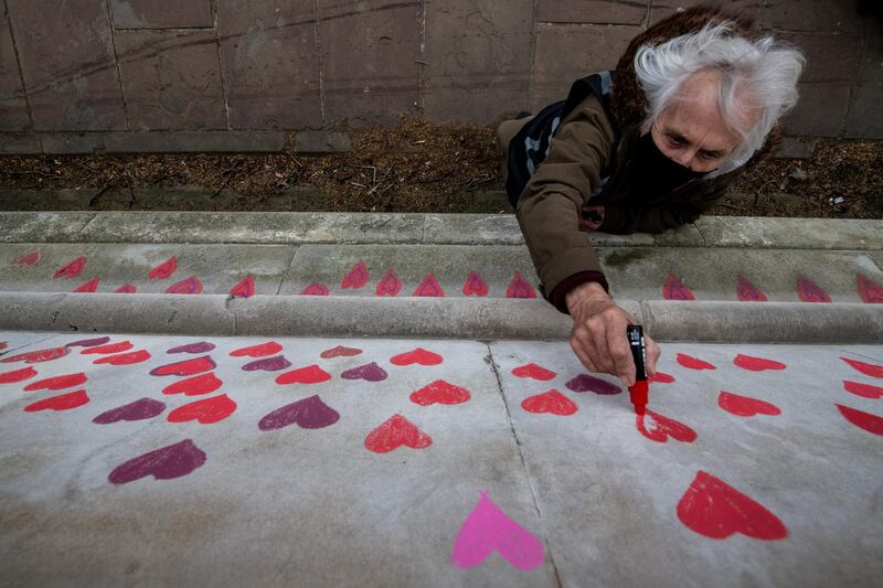 They are painting individual red hearts for each of the lives lost to the virus. Getty Images
