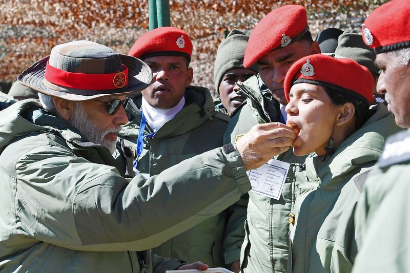 Mr Modi offers traditional sweets to a young cadet.