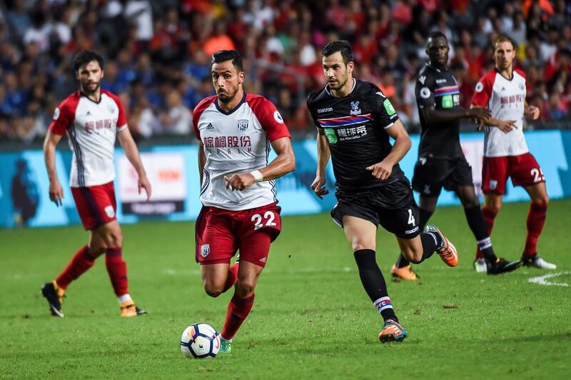 Nacer Chadli (centre L) of West Bromwich Albion controls the ball as Luka Milivojevic (centre R) of Crystal Palace gives chase during the third-place playoff match of the Premier League Asia Trophy football tournament between West Bromwich Albion and Crystal Palace in Hong Kong on July 22, 2017. / AFP PHOTO / ISAAC LAWRENCE / RESTRICTED TO EDITORIAL USE. No use with unauthorized audio, video, data, fixture lists, club/league logos or 'live' services. Online in-match use limited to 75 images, no video emulation. No use in betting, games or single club/league/player publications.