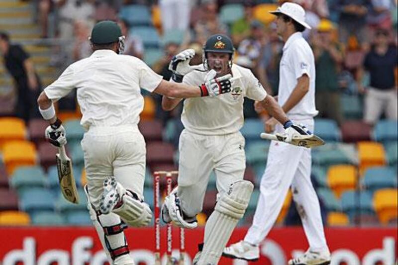 Australian batsman Mike Hussey celebrates his century with his batting partner Brad Haddin during the third day of the first Ashes cricket Test match