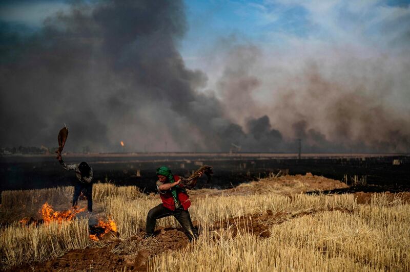 People battle a blaze in an agricultural field in the town of al-Qahtaniyah, in the Hasakeh province near the Syrian-Turkish border. AFP