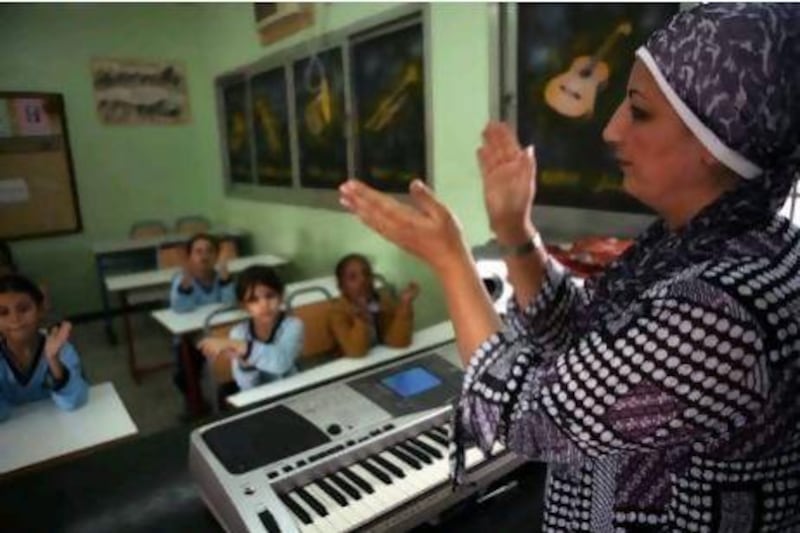 Dubai, UAE - December 10, 2009 - Teacher Shussoun Al Beik teaches a 4th grade music class at the National Charity School. (Nicole Hill / The National) *** Local Caption *** NH School00001.jpg