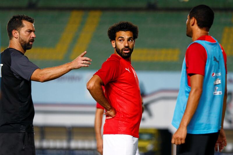 Salah listens to a member of Egypt's coaching staff during a training session in Cairo. Reuters