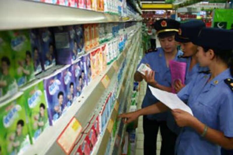 Chinese food safety officers inspect Mengniu branded milk  at a supermarket in Fuyang, China.