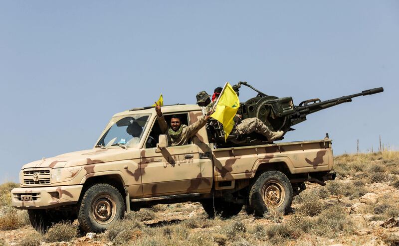 A picture taken on July 26, 2017 during a tour guided by the Lebanese Shiite Hezbollah movement shows members of the group manning an anti-aircraft gun mounted on a pick-up truck in a mountainous area around the Lebanese town of Arsal along the border with Syria.
Lebanese movement Hezbollah said the previous week that its fight against militant groups along the eastern border with war-ravaged Syria was "nearing its end", and called on fighters to surrender. / AFP PHOTO / ANWAR AMRO