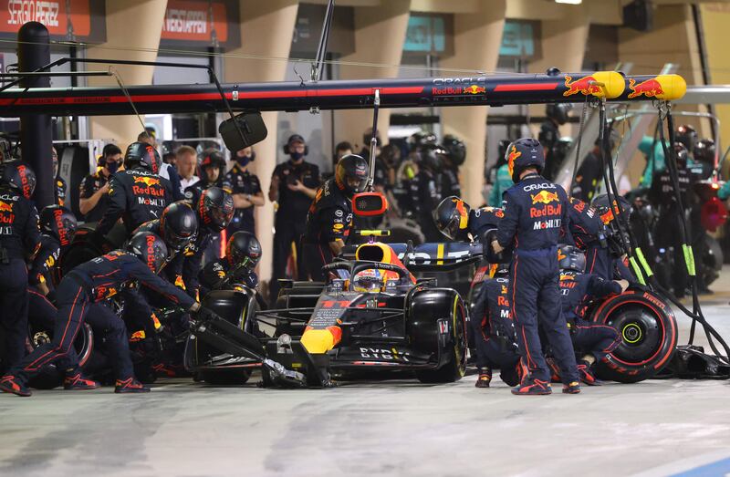 Red Bull's Mexican driver Sergio Perez is assisted by mechanics during a pit stop. AFP