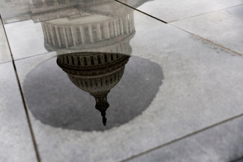 The US Capitol reflected in a puddle, as President Joe Biden waits to see if his debt-ceiling bill will be passed. Reuters