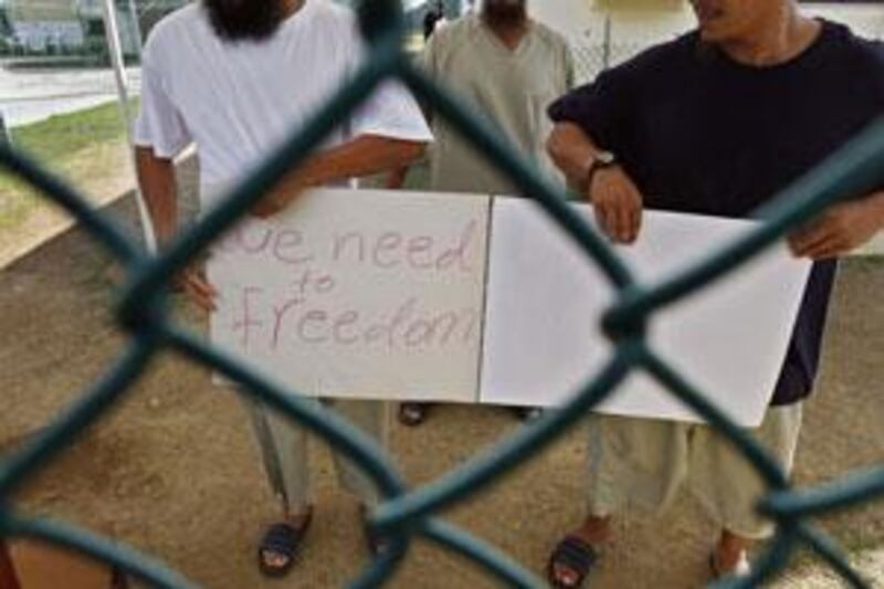 Chinese Uighur Guantanamo detainees, who at the time were cleared for release but had no country to go to, show a home-made note to visiting members of the media.