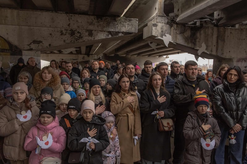 Local residents attend a memorial ceremony under a destroyed bridge in Irpin, Kyiv, on the second anniversary of Russia's invasion of Ukraine. AFP