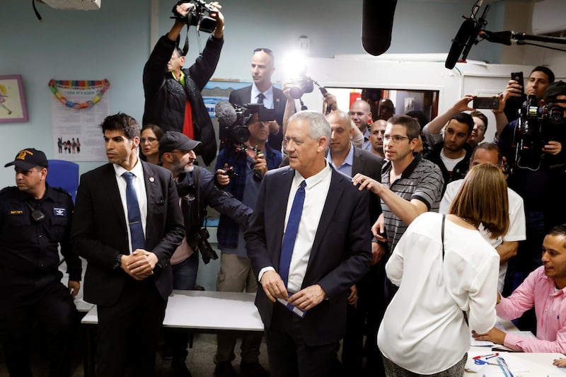 Benny Gantz, leader of Blue and White party, is surrounded by members of the media as he votes at a polling station as Israelis began voting in a parliamentary election. Reuters