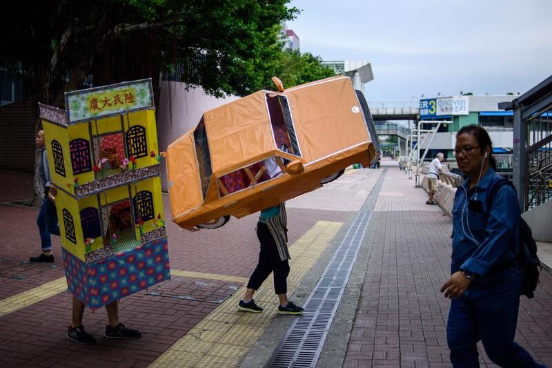 Workers carry paper replicas of everyday items traditionally used by Chinese as offerings to pay respects to the dead in Hong Kong. Anthony Wallace / AFP / May 19, 2017
